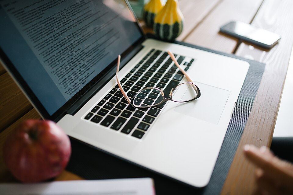 Reading glasses resting on a laptop keyboard