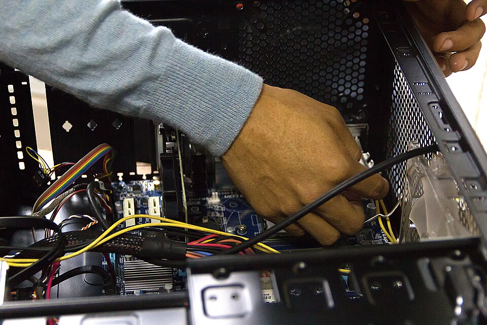 Hands working inside a desktop computer case